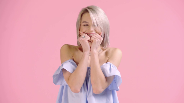 ενθουσιασμένοι κορίτσι καλύπτει το στόμα και δείχνει το νικητή χειρονομία απομονώνονται σε ροζ - Πλάνα, βίντεο