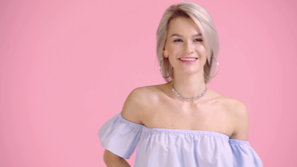 fröhliches Mädchen in Bluse mit nackten Schultern posiert isoliert auf rosa - Filmmaterial, Video