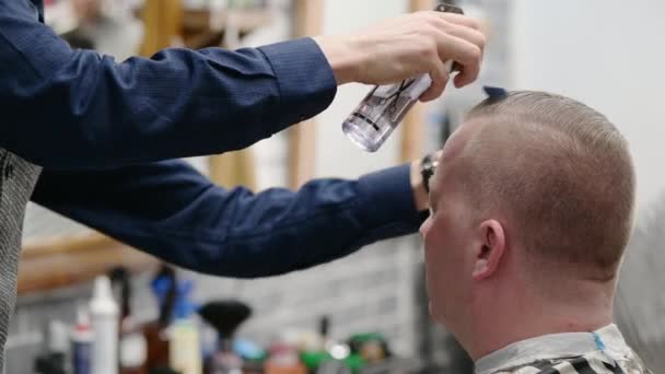 Mens haircut in Barbershop. Close-up of master dampens and combs clients hair - Video