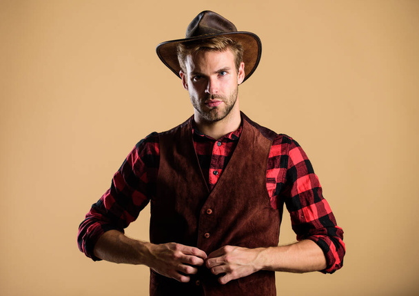 Cowboy wearing hat. Western life. Man unshaven cowboy beige background. Unshaven guy in cowboy hat. Handsome bearded macho. American cowboy. Beauty standard. Example of true masculinity - Photo, Image