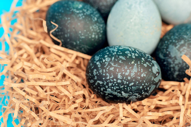 De beaux œufs de Pâques de couleur foncée, comme un cosmos, reposent dans un nid
 - Photo, image