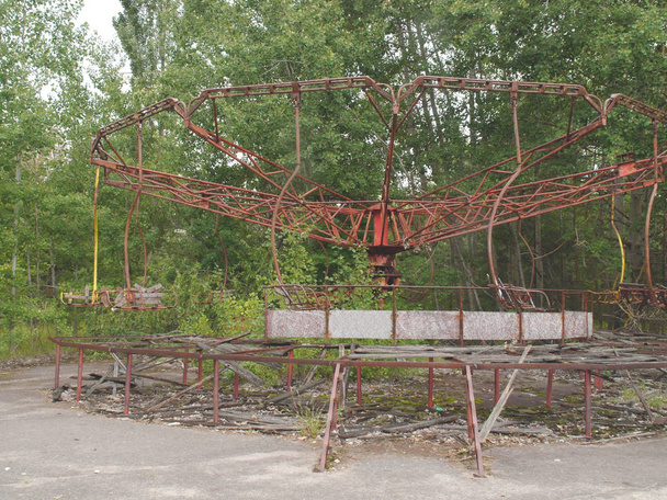 Εγκαταλελειμμένο σκουριασμένο καρουζέλ σε πάρκο της πόλης.Άποψη της εγκαταλελειμμένης πόλης Pripyat, πόλη φάντασμα κοντά στο πυρηνικό εργοστάσιο του Τσερνομπίλ. - Φωτογραφία, εικόνα