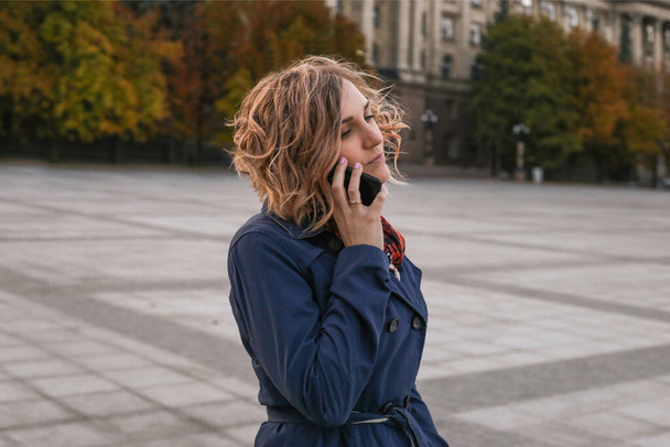 Európai lány beszél telefonon egy történelmi épület hátterében - Fotó, kép