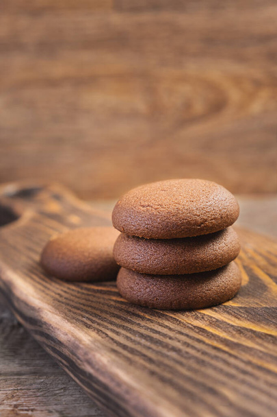 Chocolate cookie on a wooden cutting board - 写真・画像