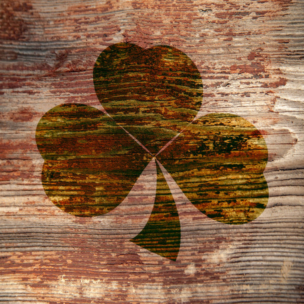 Saint Patrick. Sentier sombre de trèfle à trois feuilles sur une surface en bois
. - Photo, image