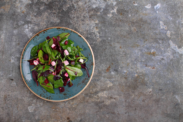 Healthy green salad of beets and feta cheese on a dark background, top view - Photo, image