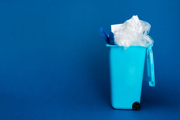 poubelle jouet avec déchets sur fond bleu avec espace de copie
  - Photo, image