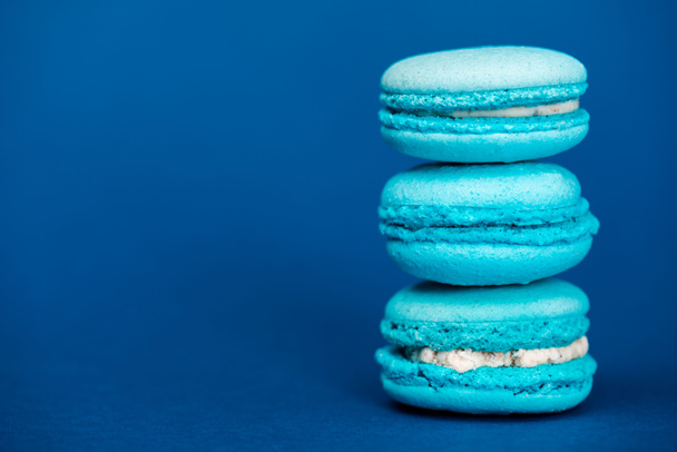 tasty french macaroons on blue background with copy space  - Photo, Image