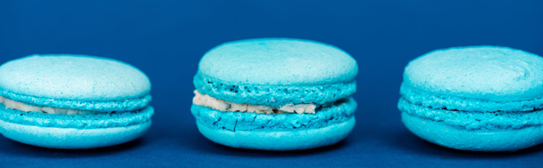 panoramic shot of french macaroons on blue background  - Фото, зображення