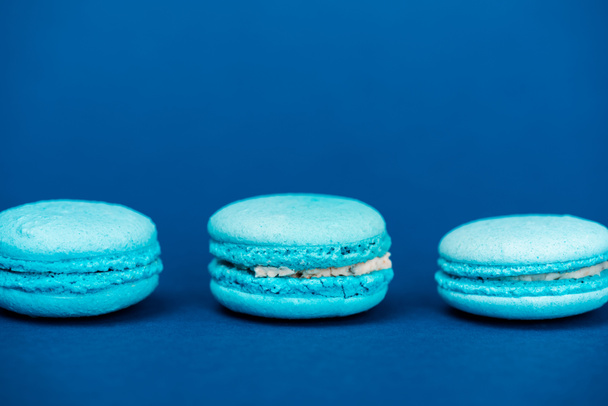 tasty french macaroons on blue background with copy space  - Photo, Image
