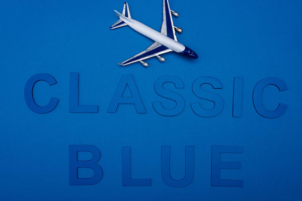 cropped view model of plane and classic blue lettering on blue background  - Foto, Bild
