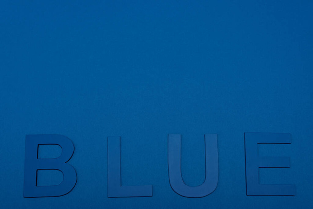 top view of blue lettering isolated on blue - Foto, Bild