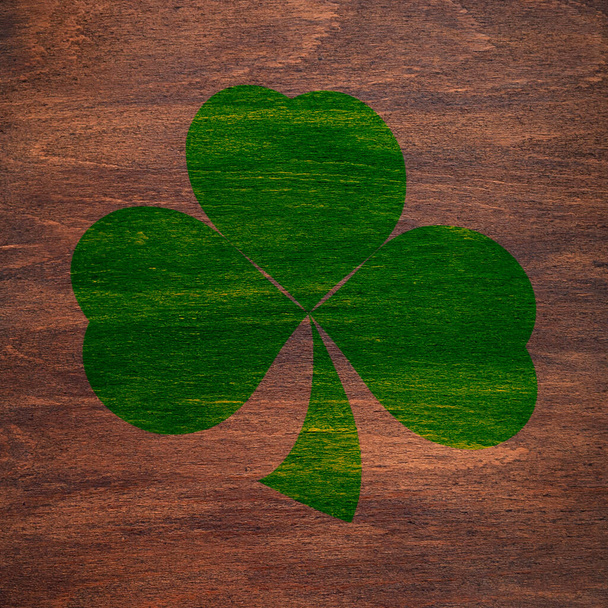 St. Patrick's Day. Green shamrock is painted on a wooden surface. Three leaf clover.  - Photo, Image