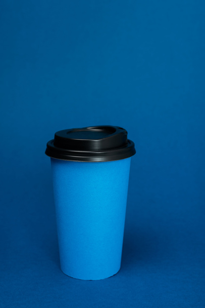 paper cups with coffee on classic blue background with copy space - Foto, imagen