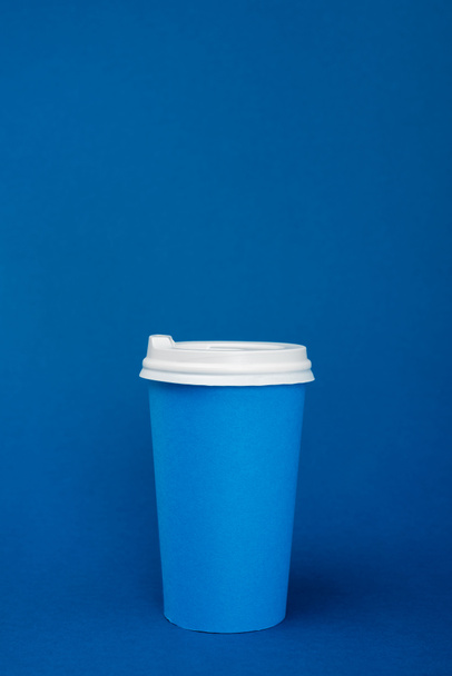 paper cup with coffee on blue background with copy space - Valokuva, kuva