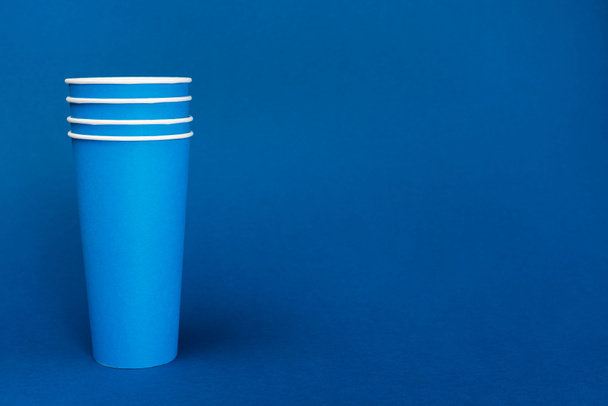 gobelets en papier lumineux sur fond bleu avec espace de copie
 - Photo, image