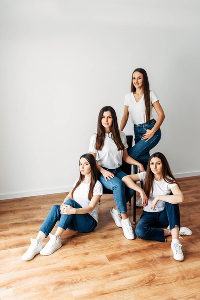 Four brunette girls in white t-shirts posing - 写真・画像