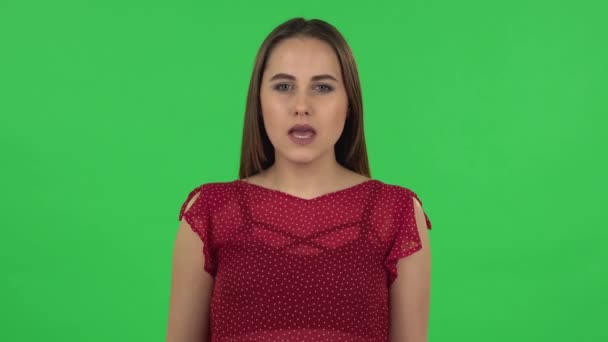 Portrait of tender girl in red dress is screaming calling someone. Green screen - Video