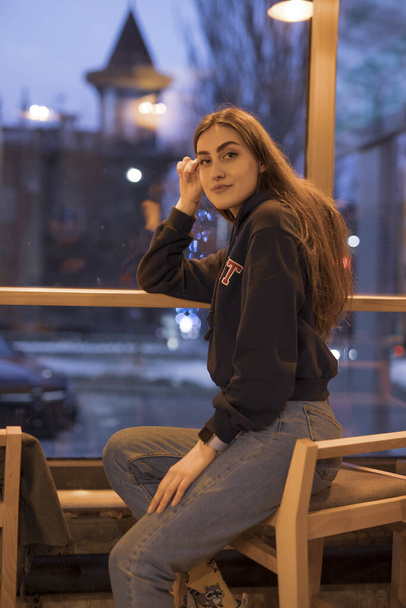 Portrait of woman sitting in evening cafe - Foto, Bild