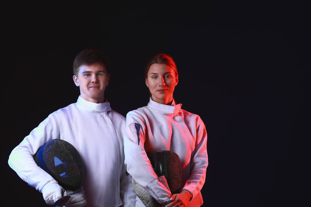 Toned photo of young fencers on dark background - Foto, Bild