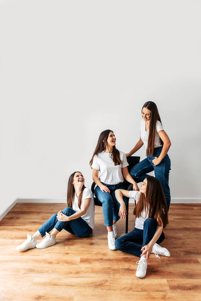 Four brunette girls in white t-shirts posing - Foto, afbeelding