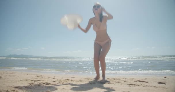 SLOW MOTION: Smiling Young bikini sexy asian woman playing freedom at seaside beach tropical resting and relaxation travel lifestyle concept - Video