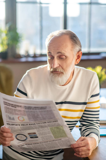 Grey-haired bearded man in striped sweater looking doubtful - Foto, Imagem