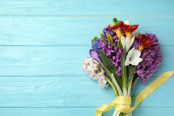 Kytice krásných jarních květin na modrém dřevěném stole, výhled shora. Mezera pro text - Fotografie, Obrázek