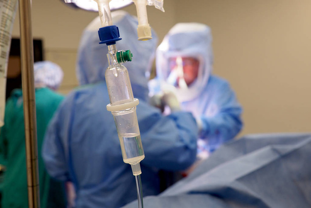 Chirurdzy i kroplówka dożylna w sali operacyjnej - Zdjęcie, obraz