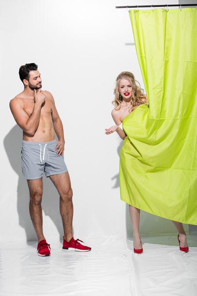 happy man looking at pin up girl standing near shower curtain on white  - Φωτογραφία, εικόνα