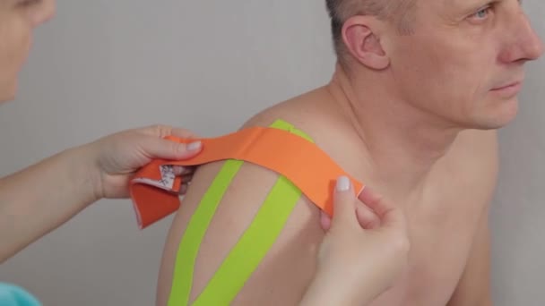 The doctor glues a special treatment tape to a man. - Footage, Video