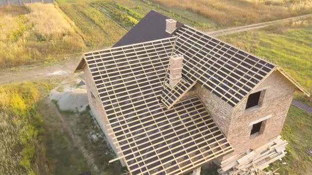 Вид с воздуха на недостроенный дом с деревянной крышей, покрытой металлическими плитками в стадии строительства. - Кадры, видео