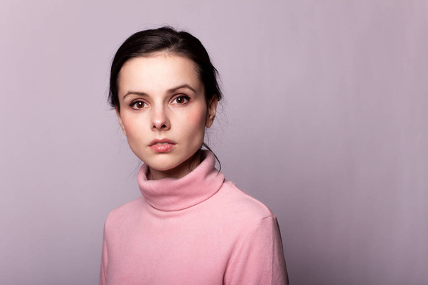 beautiful girl in a pink turtleneck on a gray background - Фото, изображение