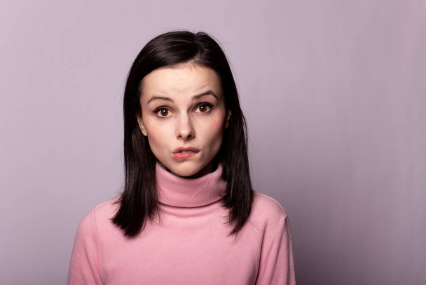 beautiful girl in a pink turtleneck on a gray background - Foto, imagen