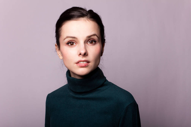 beautiful girl in a green turtleneck on a gray photo - Foto, afbeelding