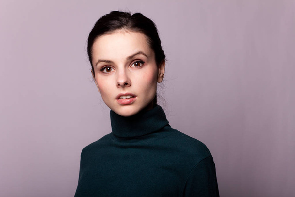 beautiful girl in a green turtleneck on a gray photo - 写真・画像