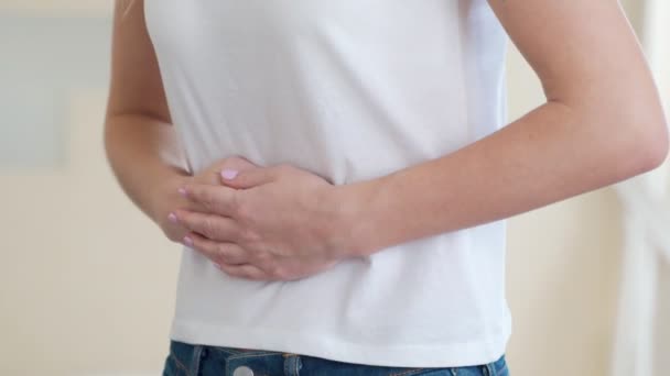 Kobieta cierpiąca na bóle brzucha w domu - Materiał filmowy, wideo