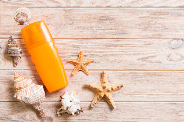 sun protection cream bottle and seashells on wooden background w - Φωτογραφία, εικόνα