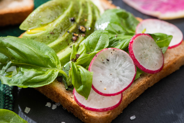 close up of fresh sandwiches with radish, basil and avocado on cloth - Fotografie, Obrázek