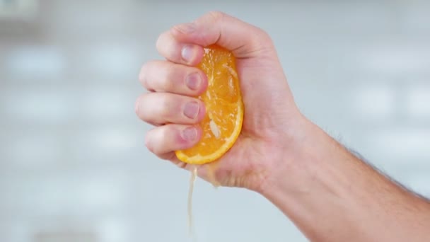 Squeezes orange juice with his hands - Кадры, видео