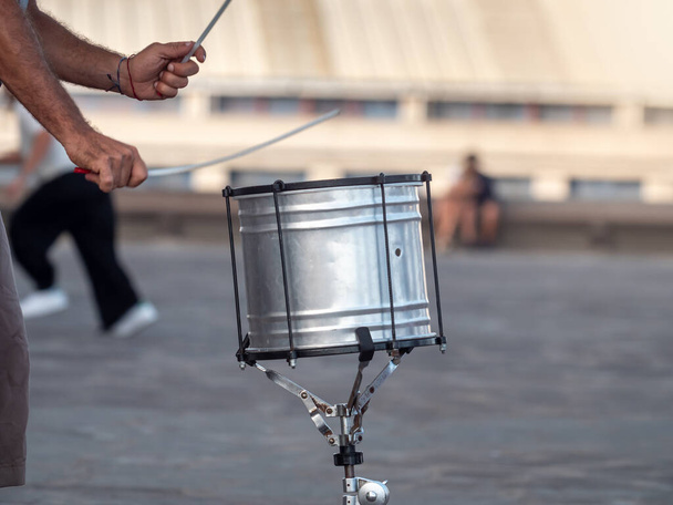 Closeup image of male street musician plaing on drums with drum sticks - Foto, Imagen