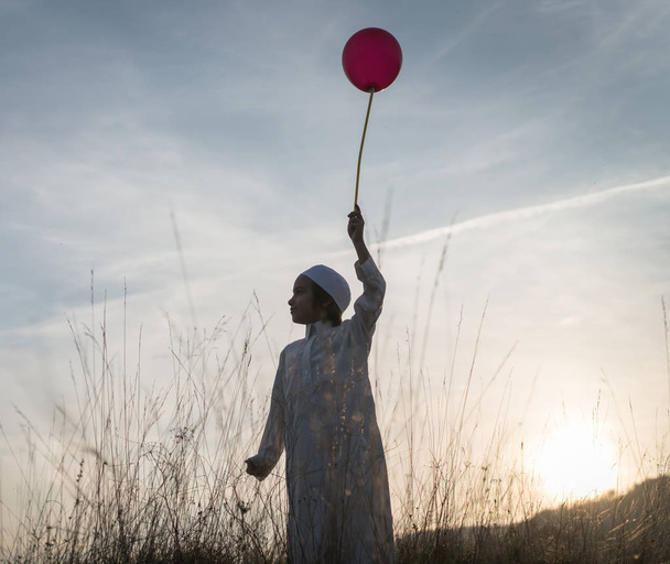 Muslim little child on grass meadow with balloon - Valokuva, kuva