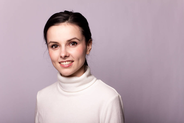 girl in a white turtleneck, portrait on a gray background - Photo, image