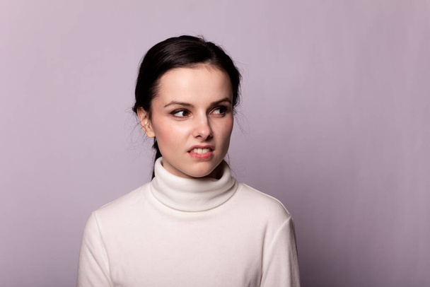 girl in a white turtleneck, portrait on a gray background - Foto, afbeelding