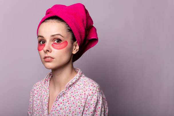 young woman after a shower in a pink towel and patches - Foto, imagen