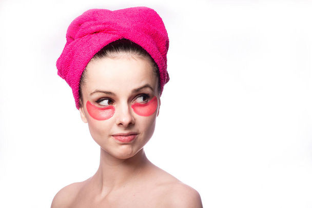 Nuori nainen suihkun jälkeen vaaleanpunaisessa pyyhkeessä ja laastareita
 - Valokuva, kuva