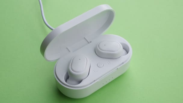 Zamknij bezprzewodowe słuchawki ładowania na zielonym ekranie - Materiał filmowy, wideo