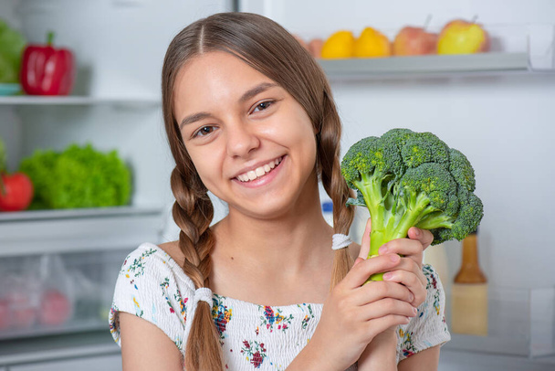 Girl with food near fridge - Foto, imagen