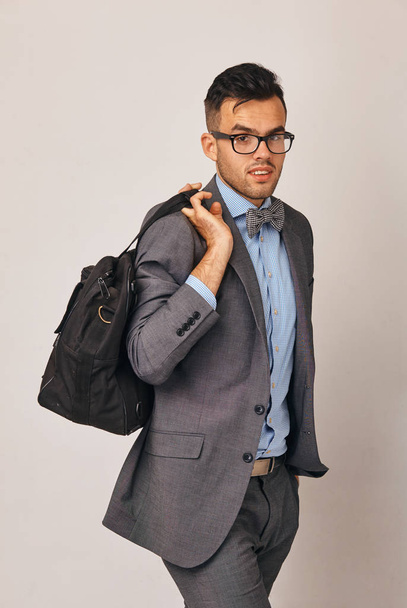 a spectacular young businessman in suit with big bag - Photo, Image