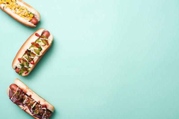 top view of three unhealthy hot dogs on blue - Foto, immagini